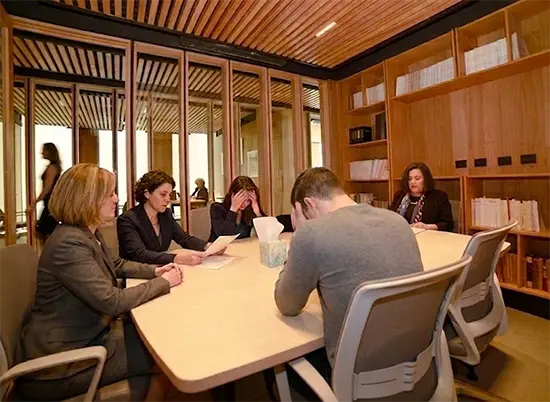 Abogados reunidos con una pareja en la sala de reuniones del estudio